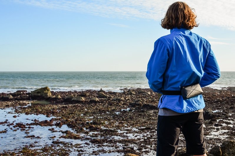 Black Spinlock Alto Inflatable Belt Pack worn by model on the shoreline