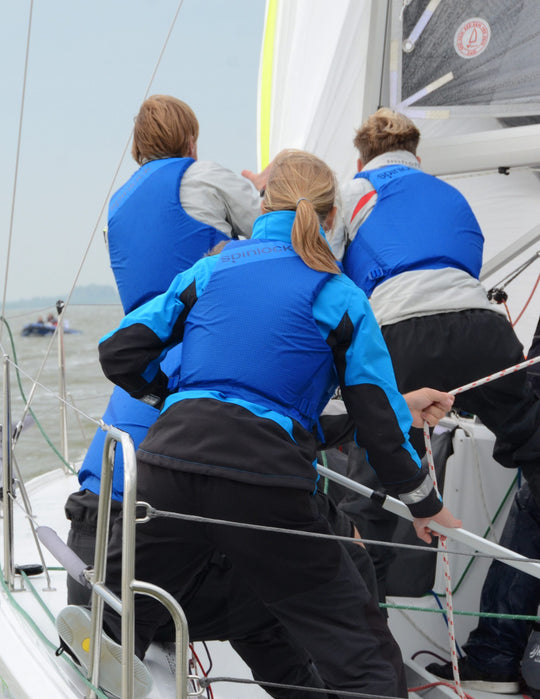 sailors wearing blue Spinlock buoyancy aid in action shot