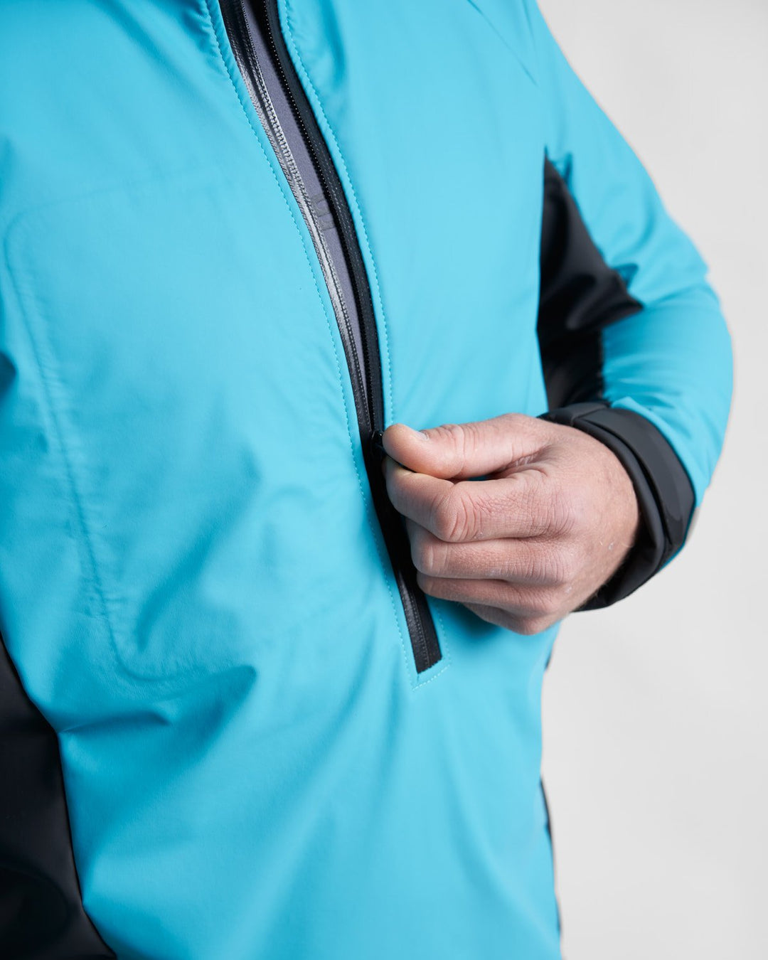 Detail image showing the front zip of a teal Rooster Active Aquafleece Top