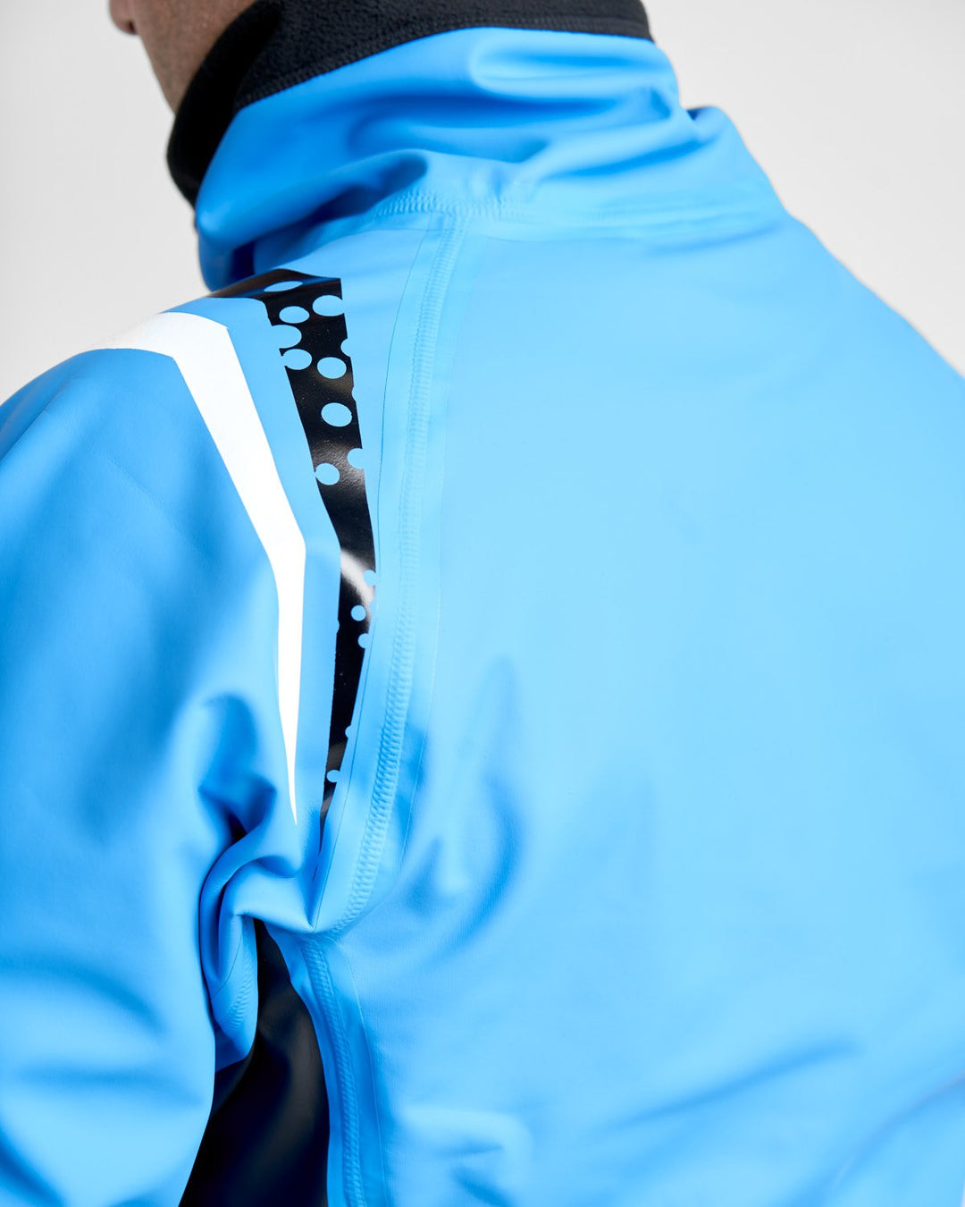 Back and Shoulder Detail of Rooster Pro Aquafleece Top in Blue, Worn by a Male Model in a studio