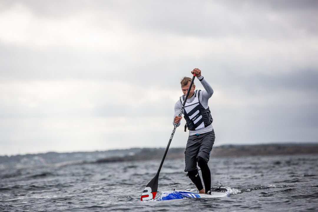 Baltic SUP Pro Buoyancy Aid In White On A Male Paddleboarder